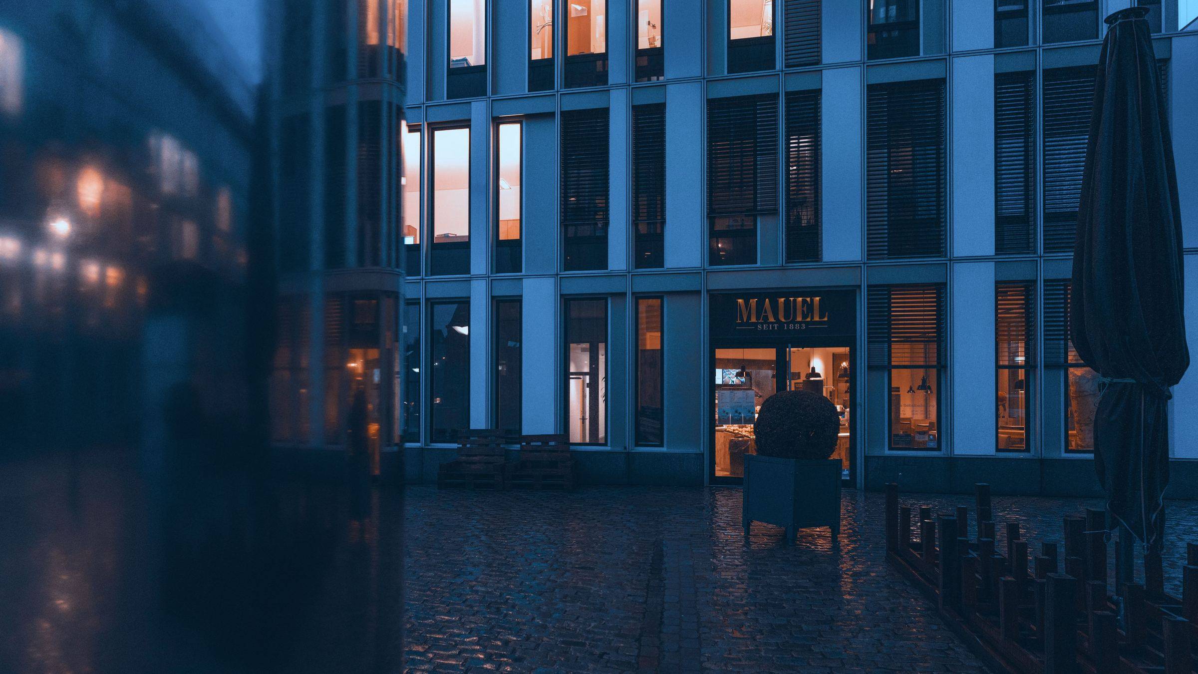 Gewerbeobjekt mit beleuchtetem Eingangsbereich in der Abenddämmerung