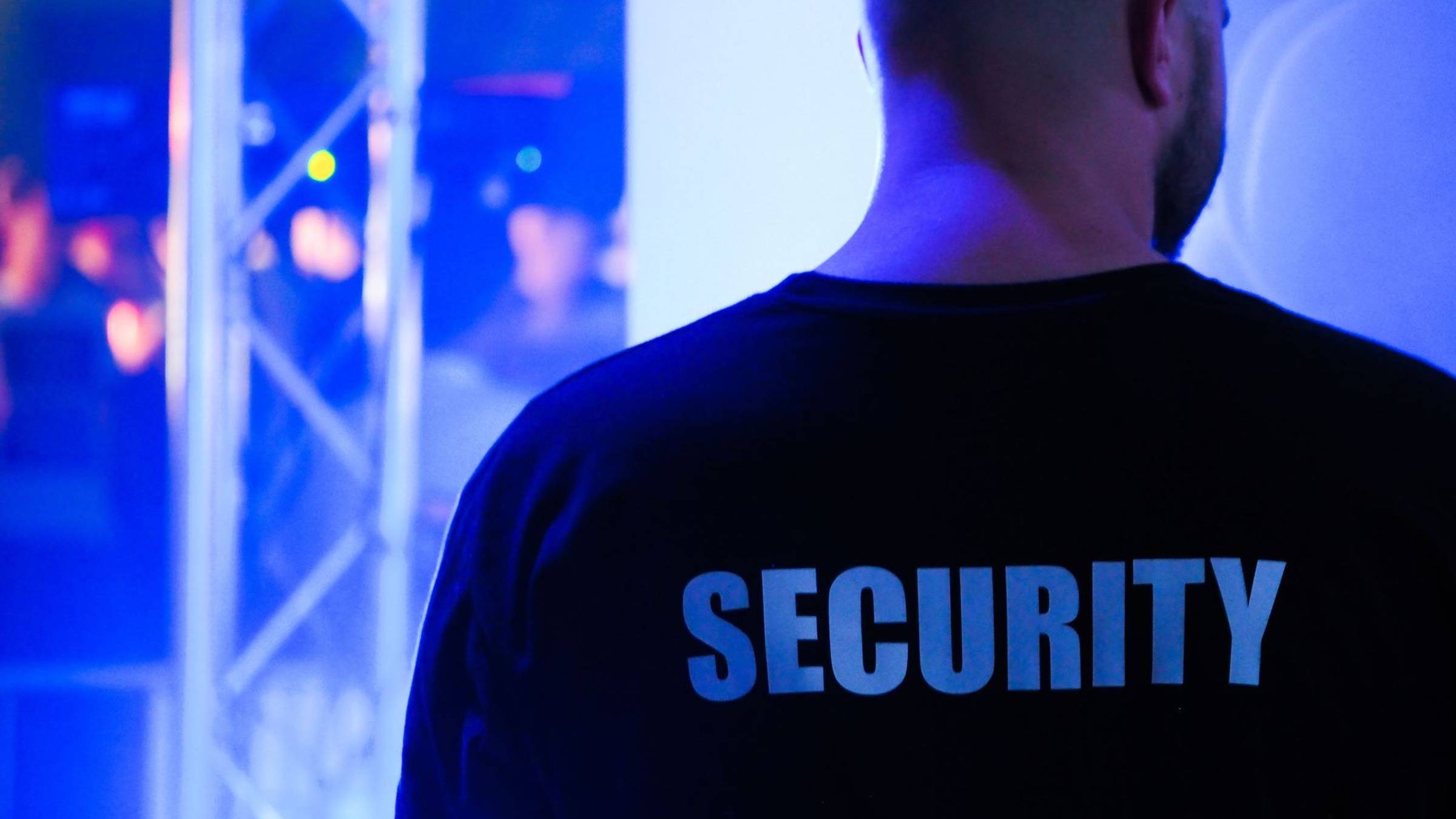 Sicherheitsmitarbeiter in navyfarbener Security-Jacke im Eingangsbereich